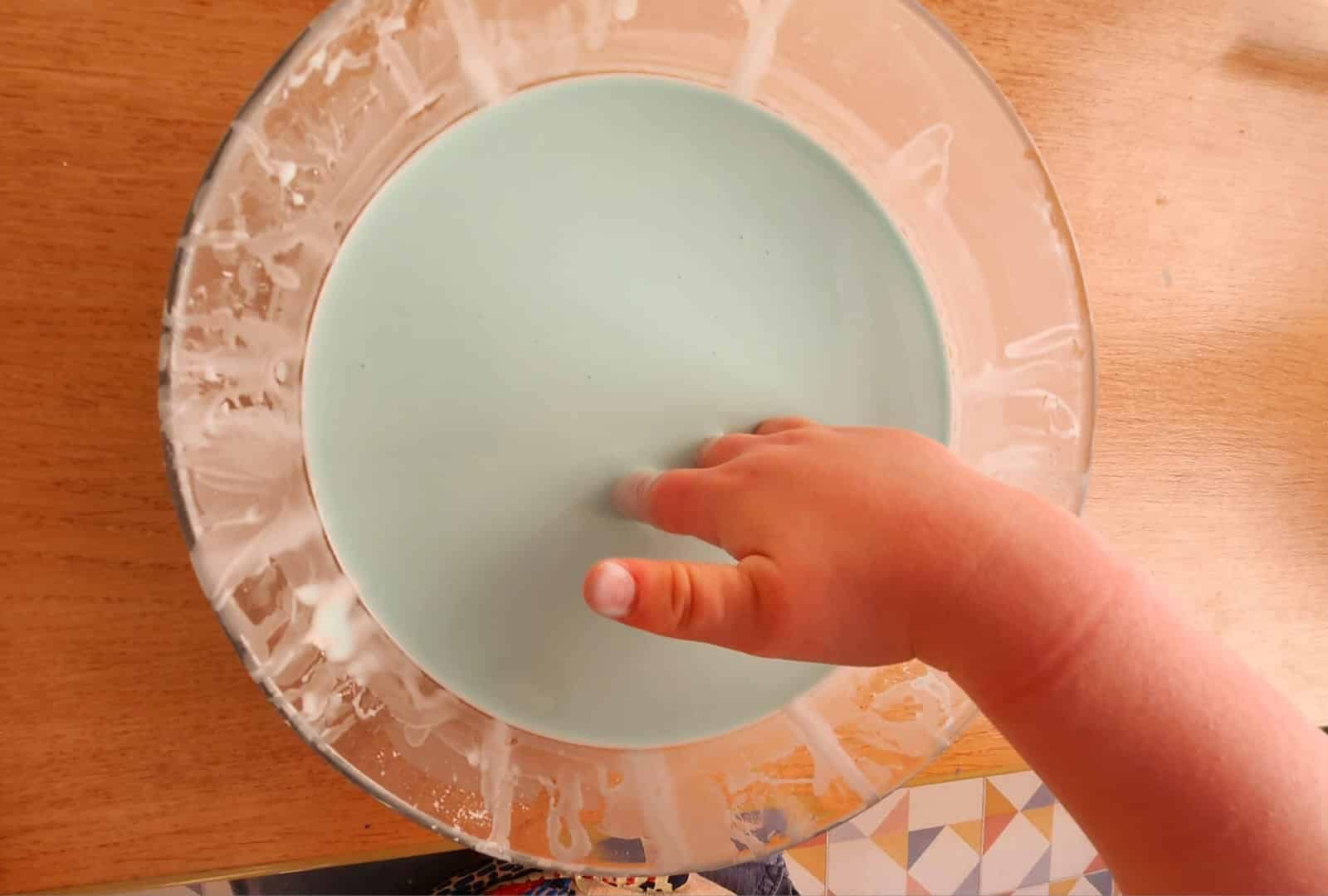 Main d’un enfant plongeant dans un mélange de maïzena et d’eau, illustrant l’expérience du fluide non newtonien (oobleck).