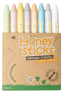 Boîte de craies grasses naturelles Honeysticks pastel jumbo, présentée en éventail au-dessus de l’emballage kraft