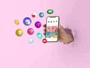 Une main tenant un smartphone affichant une application de réseaux sociaux, entouré d'icônes symbolisant la communication et l'engagement en ligne, illustrant la pression parentale due aux réseaux sociaux.