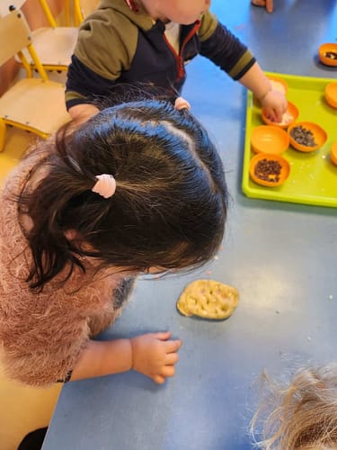 Un enfant participe à un atelier cuisine, observant une préparation sur la table